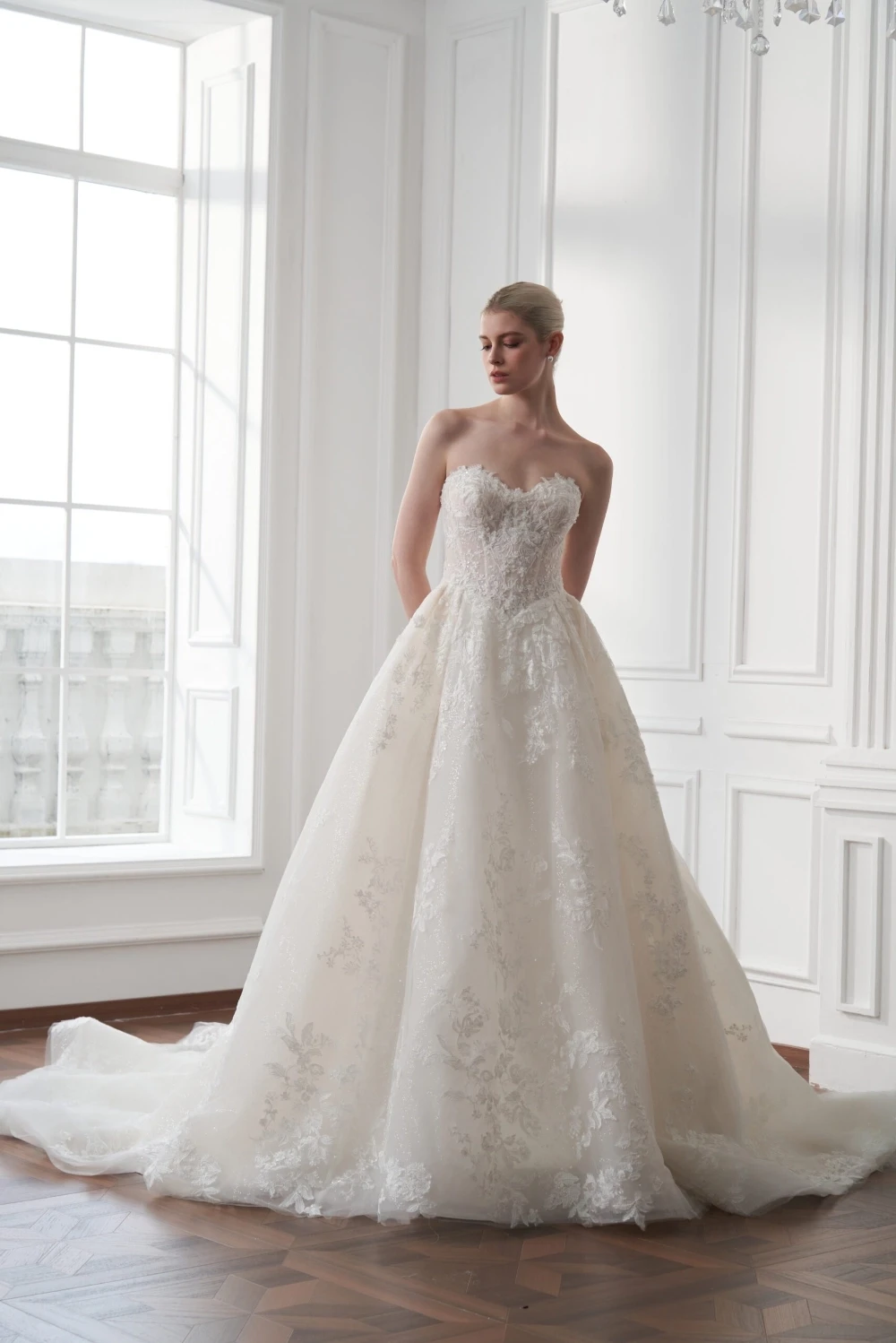 Bride in a strapless lace ball gown with a sweetheart neckline and floral detailing.