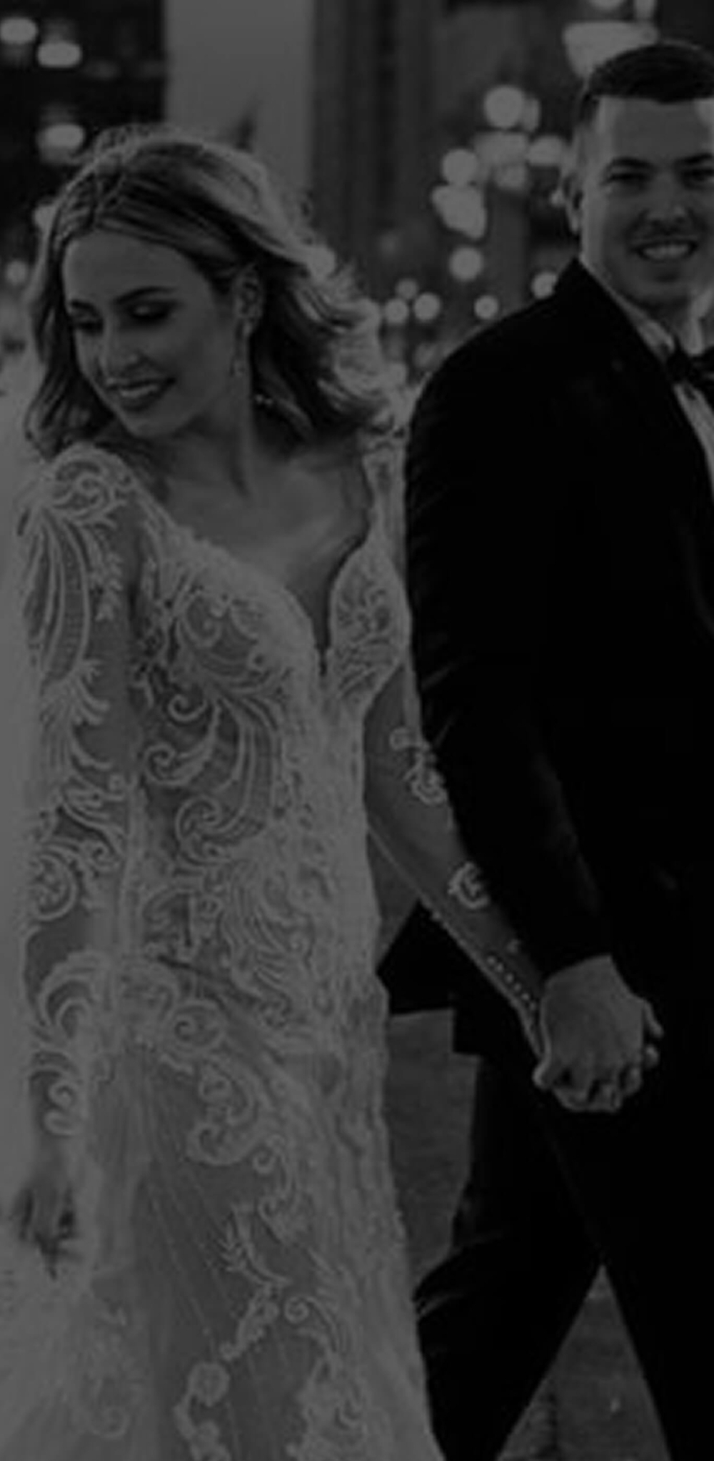 Сouple wearing a white gown and a black suit. Mobile image